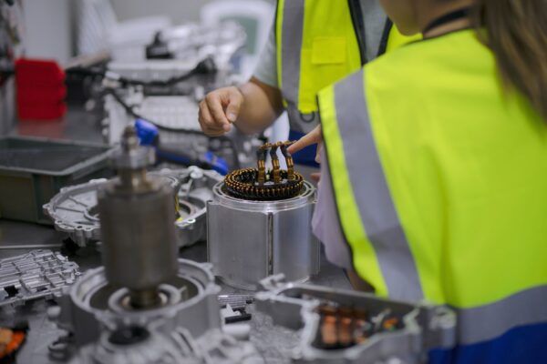 Mechanics working on electric vehicle components in a workshop