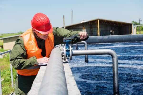 Engineer conducting inspection of wastewater treatment valves and piping